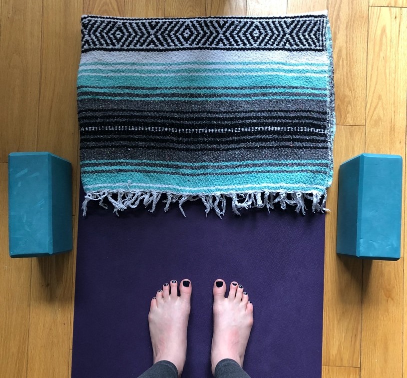 Feet on yoga mat and blocks beside them. 